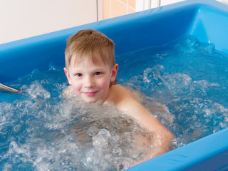 baby boy is taking a bath with bubbles. Jacuzzi bubble bath procedure.