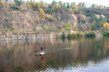 Sports woman paddleboarding on the mountain lake
