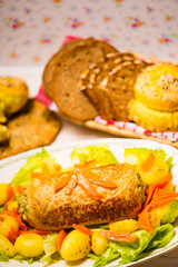 Meatloaf with spinach stuffing served with fried potatoes and carrot.