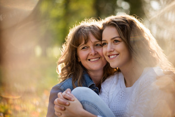 Happiness - mature mother with her adult daughter in nature