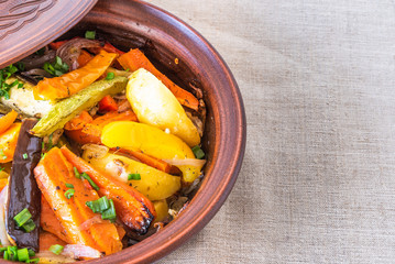 Traditional Moroccan and Algerian cuisine - vegetarian dish, tajine or tagine with potatoes, eggplants, zucchini and pepper, copy space