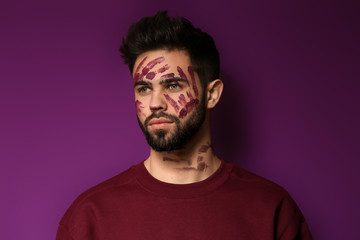 Portrait of handsome man with paint on his face against color background