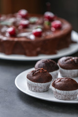 Plate with tasty chocolate muffins on table