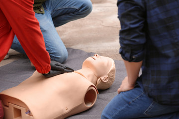 Instructor demonstrating CPR on mannequin at first aid training course
