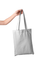 Female hand holding eco bag on white background