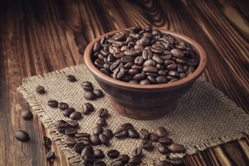Roasted coffee beans on a wooden background from burnt wood