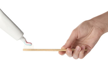 Squeezing of paste on toothbrush against white background