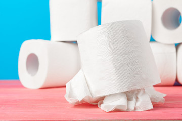 Toilet paper rolls stacked against blue background