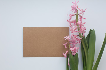 Paper craft blank with pink hyacinth flowers with leaves on white background. Flat lay, copy space, top view. Flowers composition.