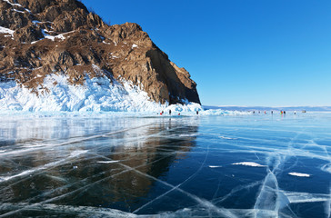 Winter landscape of frozen lake Baikal. Fields of smooth blue ice with cracks near the coastal...