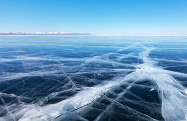 Typical winter landscape of frozen lake Baikal. Endless fields of smooth blue ice with cracks...