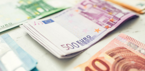 Several hundred euro banknotes stacked by value