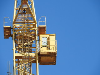 Fototapeta na wymiar Large construction site, including several cranes working on the construction complex, with a clear blue sky.