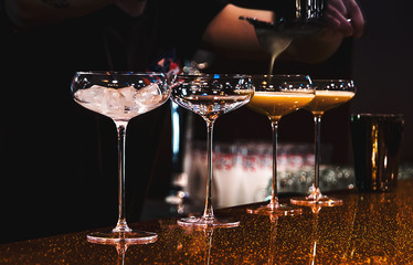 Bartender making cocktails on bar counter in the nightclub cocktail party