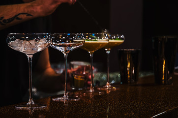 Bartender making cocktails on bar counter in the nightclub cocktail party