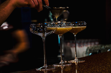 Bartender making cocktails on bar counter in the nightclub cocktail party