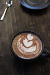 a cup of latte art coffee on wooden background