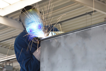 welder works in metal construction - construction and processing of steel components