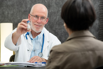 mature doctor giving pills at his patient