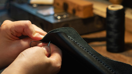 Leather handbag craftsman at work in a workshop - obrazy, fototapety, plakaty