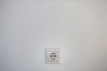 White electrical socket is placed on a wall.
