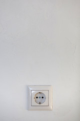 White electrical socket is placed on a wall.