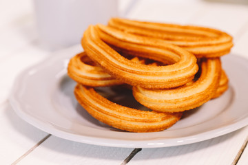 spanish fritters served on white dish on a wooden table