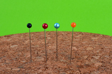 Multi colored push pins on corkboard