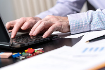 Hands of businessman using laptop, light effect