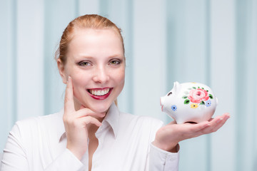 young red haired woman with her piggy bank