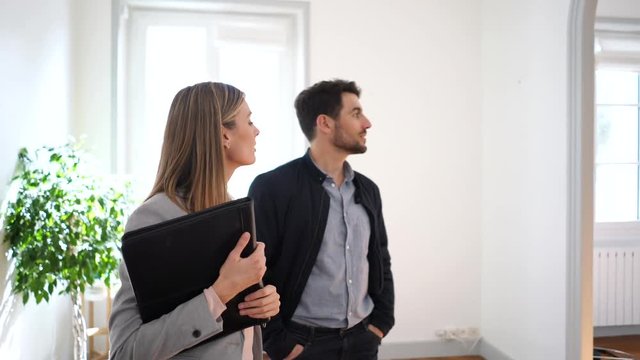 Female real estate agent showing spacious property to buyer