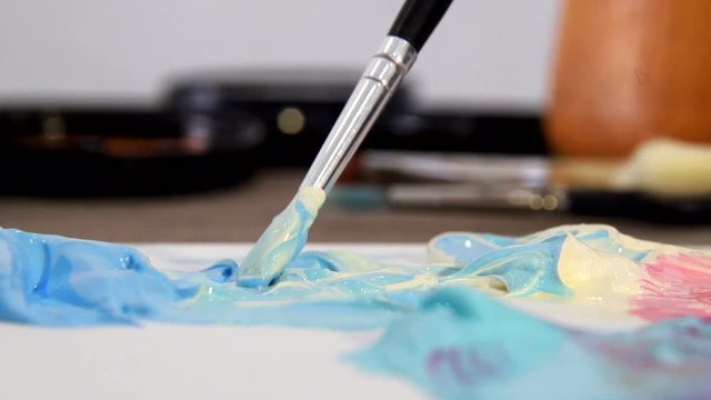 Artist mixes the paint on the Board