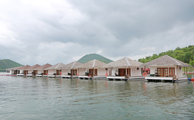 Landscape view of Thai boat and bungalows floating on river at kanchanaburi, Thailand.