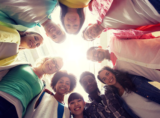 education, school, friendship and unity people concept - group of happy international students standing in circle