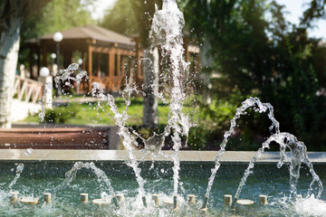 beautiful fountain in the park, a lot of jets and splashes, sunlight, close-up, concept