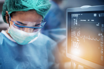 Team of doctors or surgeons with electrocardiogram monitor in hospital surgery operating emergency...