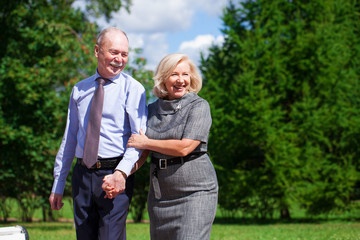 Senior couple walking in summer in park