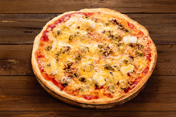 Appetizing pizza on a wooden background