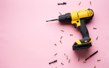 Creative provocation: a yellow screwdriver on a pink background and small screws.