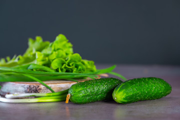 Fresh vegetables and greens for salad on a wooden surface. The concept of a healthy diet.