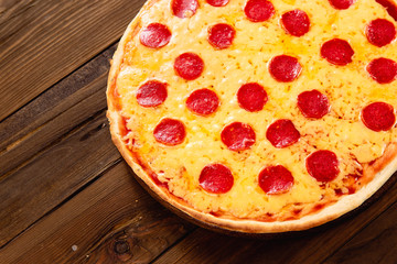Appetizing pizza on a wooden background