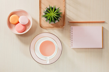 Styled stock photography beige office desk table with blank notebook, macaroon, supplies and coffee cup