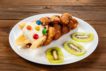 Ice cream ice cream in a waffle cone with sweets and fruit syrup