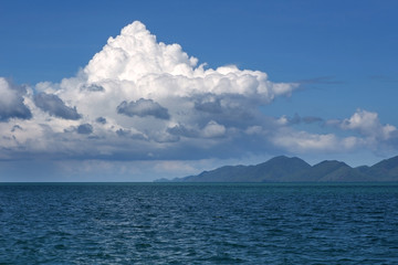 Seascape. Clouds, small hills on the horizon.