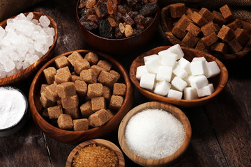 Various types of sugar, brown sugar and white on rustic wooden table