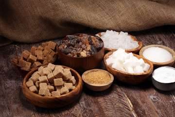 Various types of sugar, brown sugar and white on rustic wooden table