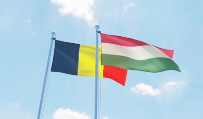 Hungary and Belgium, two flags waving against blue sky. 3d image