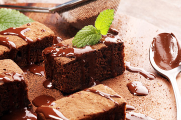 Brownie dessert. Cake chocolate brownies on wooden background with mint.