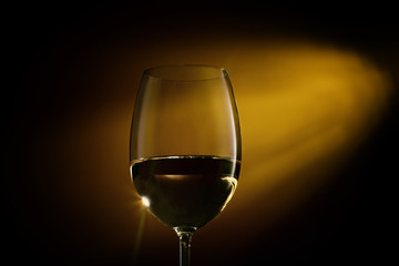 Glass filled with white wine on a gradient background. Close-up studio shot.