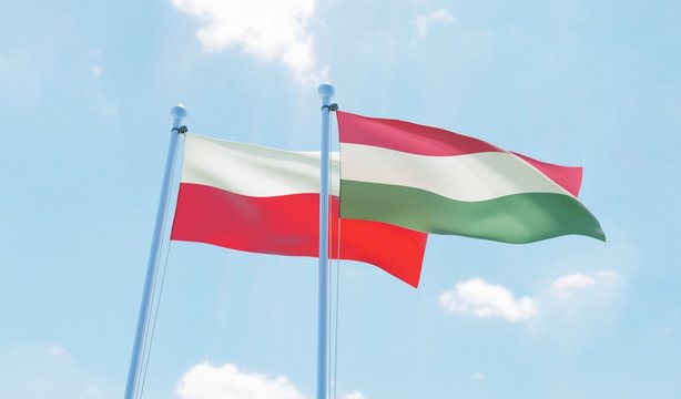 Hungary and Poland, two flags waving against blue sky. 3d image